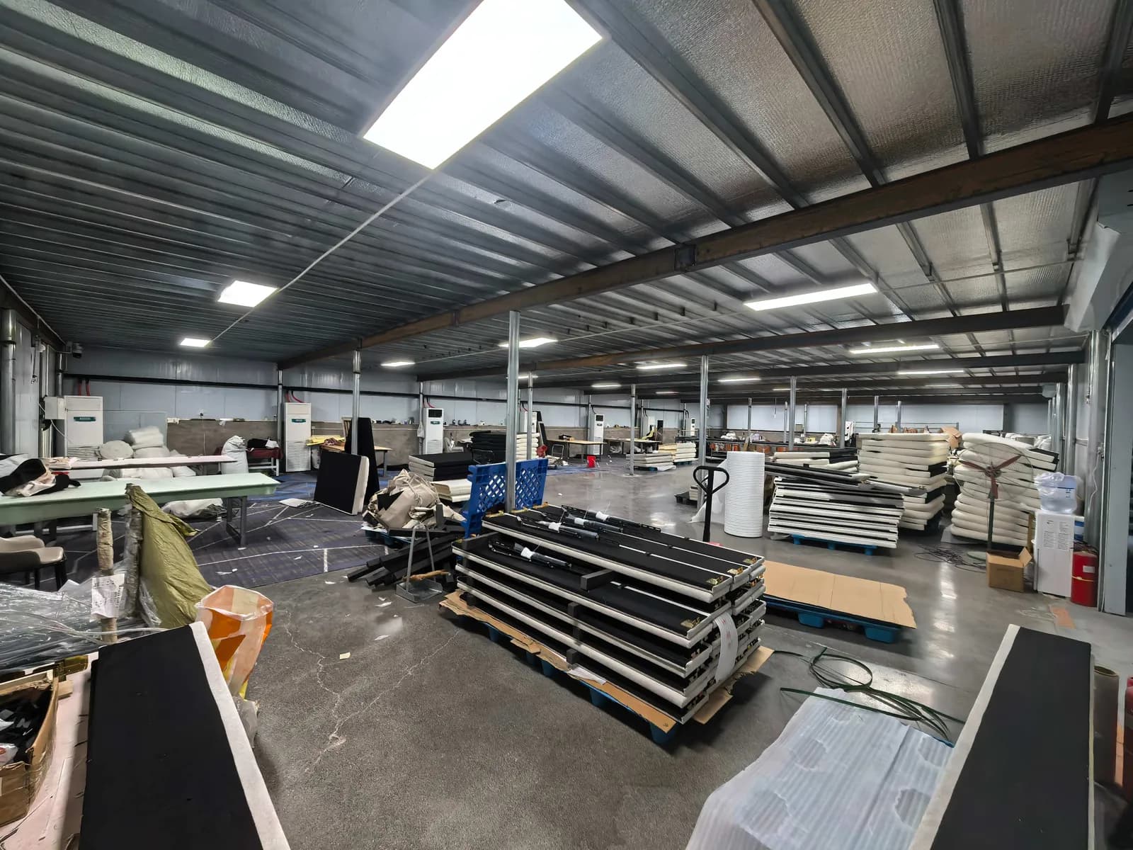 Wide view of the workshop floor with finished panels stacked for assembly