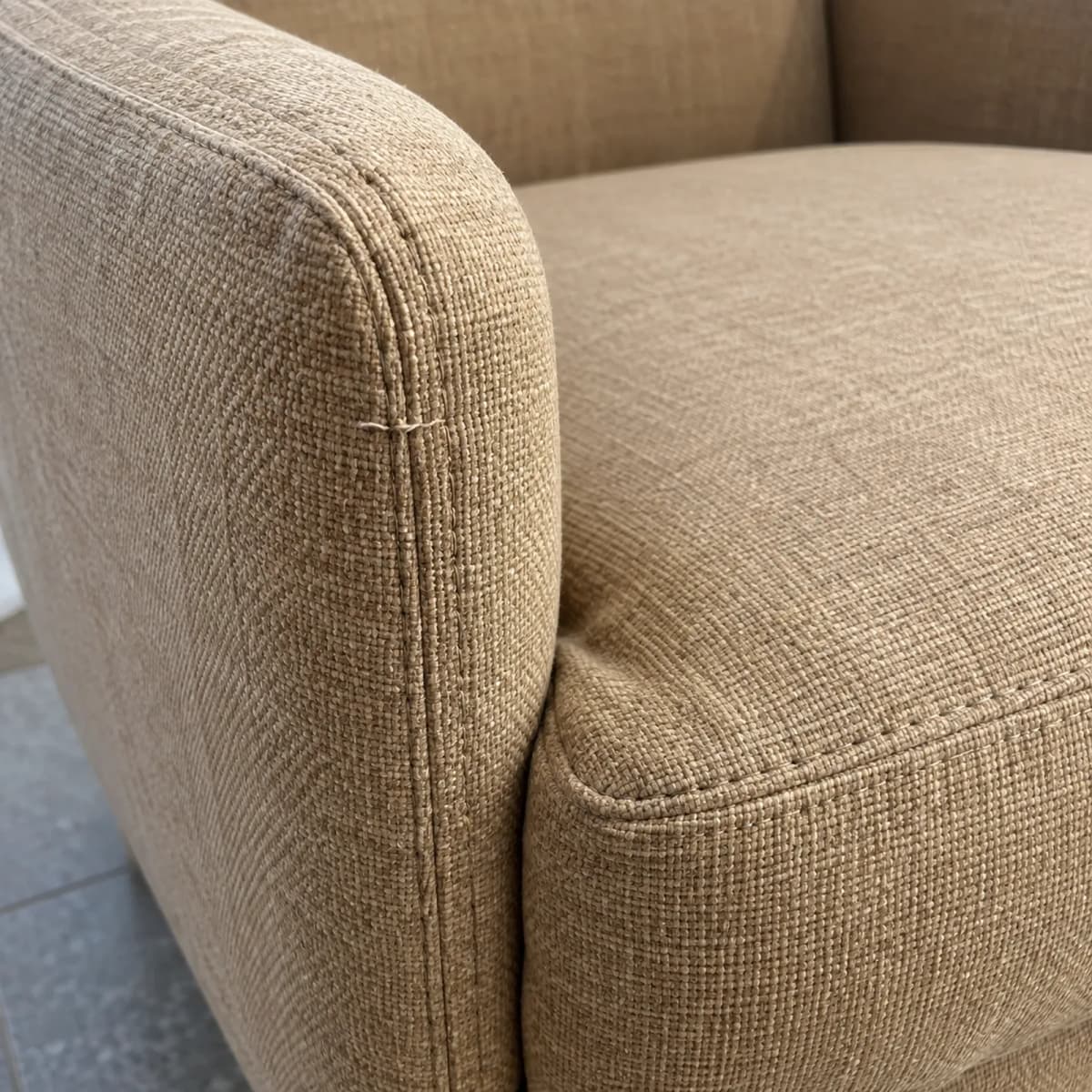 Close-up of an upholstered armchair seam and fabric weave